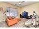 Living room with orange couch, wood floors, and large TV at 1404 W Weatherby Way, Chandler, AZ 85286