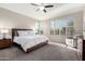 Main bedroom with wood platform bed, ceiling fan and large windows at 16333 E Lombard Pl, Fountain Hills, AZ 85268