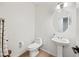 Clean and modern bathroom with pedestal sink, toilet and round mirror at 1702 E Bell Rd # 130, Phoenix, AZ 85022