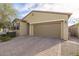 House exterior featuring a two-car garage and brick driveway at 17669 W Daley Ln, Surprise, AZ 85387