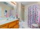 Bathroom with shower/tub combo, wood vanity, and seashell decor at 18003 N 136Th Way, Sun City West, AZ 85375