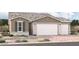 New home exterior featuring a three-car garage and desert landscaping at 18231 W Hess St, Goodyear, AZ 85338