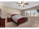 Spacious bedroom with a king-size bed, wood dresser, and large window with shutters at 2032 E Pegasus Dr, Tempe, AZ 85283