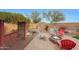 Relaxing backyard patio with fire pit, seating, and a pergola at 20587 N 259Th Dr, Buckeye, AZ 85396