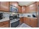 Kitchen boasts stainless steel appliances and wood cabinets at 20587 N 259Th Dr, Buckeye, AZ 85396