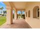 Elegant covered patio with brick flooring, arched openings, and views of the lush landscaped surroundings at 21 E Oakwood Hills Dr, Chandler, AZ 85248