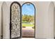 Grand arched doorway with intricate wrought iron details, welcoming natural light and beautiful outdoor views at 21 E Oakwood Hills Dr, Chandler, AZ 85248