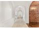 Arched hallway with brick accent wall and tiled flooring at 21 E Oakwood Hills Dr, Chandler, AZ 85248