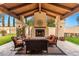 Cozy covered patio with a stone fireplace, outdoor seating, and wood beam ceiling at 21 E Oakwood Hills Dr, Chandler, AZ 85248