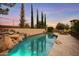 Beautiful pool with rock waterfall feature and stone tile deck surrounded by professional landscaping and secure fencing at 21 E Oakwood Hills Dr, Chandler, AZ 85248