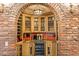 Custom wine cellar with cooler, display cabinets, lighting, and brick accents at 21 E Oakwood Hills Dr, Chandler, AZ 85248