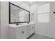 Bathroom featuring a double sink vanity, framed mirror and a large window for natural light at 26706 N 174Th Ln, Surprise, AZ 85387