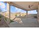 Covered patio with ceiling fan overlooks a low-maintenance backyard area with rock groundcover and xeriscaping at 26706 N 174Th Ln, Surprise, AZ 85387