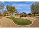 Inviting backyard featuring a putting green, hot tub, outdoor seating, and drought-tolerant desert landscaping at 3000 E Tulsa St, Gilbert, AZ 85295