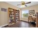 Home office with bookshelves, a wooden desk, rolling chair, and natural light from a window at 3000 E Tulsa St, Gilbert, AZ 85295