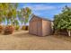 A practical shed sits on the property's rear boundary, flanked by colorful plants at 3000 E Tulsa St, Gilbert, AZ 85295