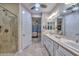 Bathroom showcasing dual sinks, tiled shower, and access to the bedroom at 30343 N 130Th Dr, Peoria, AZ 85383