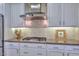 Close-up view of kitchen with stainless steel appliances, white cabinets, and tiled backsplash at 30343 N 130Th Dr, Peoria, AZ 85383