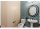 Powder room with pedestal sink, toilet and decorative mirror at 31689 N 128Th Dr, Peoria, AZ 85383