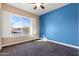 Spacious bedroom with blue accent wall and large window at 31689 N 128Th Dr, Peoria, AZ 85383