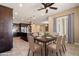 Dining area with a wooden table, seating for six, and a modern ceiling fan at 31689 N 128Th Dr, Peoria, AZ 85383