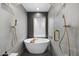 This spa-like bathroom features a soaking tub, gold fixtures, and a unique tile design at 4059 E Cholla St, Phoenix, AZ 85028