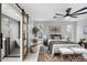 Bright main bedroom with a modern ceiling fan, large rug, and sliding barn door to the bathroom at 4059 E Cholla St, Phoenix, AZ 85028