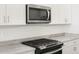 Close-up of modern kitchen features a stainless steel microwave and black gas cooktop at 4287 W Jeanette Ln, San Tan Valley, AZ 85144