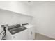 Modern laundry room featuring a washer, dryer, and white shelving at 4287 W Jeanette Ln, San Tan Valley, AZ 85144