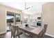 Dining area with modern light fixture, gray table and chairs, and kitchen view at 43815 W Carey Dr, Maricopa, AZ 85138