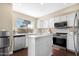 Modern kitchen with white cabinets, stainless steel appliances, and a large island at 43815 W Carey Dr, Maricopa, AZ 85138