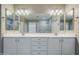 Bright bathroom features a dual sink vanity with white cabinets, dual mirrors, and updated lighting fixtures at 4647 E County Down Dr, Chandler, AZ 85249