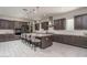 Modern kitchen with large island, granite countertops, and dark cabinets at 5080 N 184Th Ln, Litchfield Park, AZ 85340