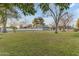 Expansive backyard featuring green lawn and mature trees under a clear blue sky at 5249 E Thunderbird Rd, Scottsdale, AZ 85254