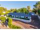 Beautiful home with a well-kept lawn, a long driveway, mature trees, and a white picket fence at 5249 E Thunderbird Rd, Scottsdale, AZ 85254