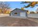 View of a detached garage with a wide driveway and white fencing surrounding the perimeter at 5249 E Thunderbird Rd, Scottsdale, AZ 85254