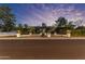 Charming single-story home featuring manicured landscaping, stone pillars, and subtle exterior lighting at dusk at 5249 E Thunderbird Rd, Scottsdale, AZ 85254