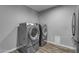 Laundry room with side by side washer and dryer set on stands with wood-look flooring at 5249 E Thunderbird Rd, Scottsdale, AZ 85254