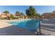 Community pool with lounge chairs, umbrellas and landscaping surrounded by residential buildings on a sunny day at 7326 N 43Rd Ave, Glendale, AZ 85301