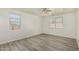 Bright bedroom with a ceiling fan and gray wood-look flooring with natural light from two windows at 7420 W Glass Ln, Laveen, AZ 85339