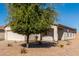 Side view of a house with a garage and mature tree in the yard at 7420 W Glass Ln, Laveen, AZ 85339