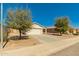 View of a single-story home with mature landscaping and a long driveway at 7420 W Glass Ln, Laveen, AZ 85339