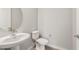 A pedestal sink and toilet are featured in this modern powder room with neutral color palette at 7659 W Cactus Wren Way, Florence, AZ 85132