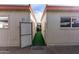 Through a gate showing a private backyard area with artificial turf, seating, and dining at 7810 N 47Th Ave, Glendale, AZ 85301