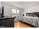 Cozy bedroom featuring a queen bed, wood floors, and view of the neighborhood at 7810 N 47Th Ave, Glendale, AZ 85301