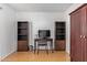 Bright home office with desk, chair, TV, two cabinets and wood flooring at 7810 N 47Th Ave, Glendale, AZ 85301