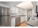 Bright kitchen with stainless steel refrigerator, dishwasher, wooden floor and white cabinets at 7810 N 47Th Ave, Glendale, AZ 85301