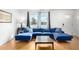 Bright living room with a blue sectional sofa, hardwood floors, and modern lighting at 7810 N 47Th Ave, Glendale, AZ 85301