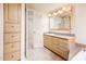 Bathroom with light wood vanity and a large mirror at 7837 E Crestwood Way, Scottsdale, AZ 85250