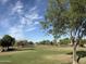 Expansive community park featuring lush green lawns and a walking path lined with mature trees on a sunny day at 7837 E Crestwood Way, Scottsdale, AZ 85250
